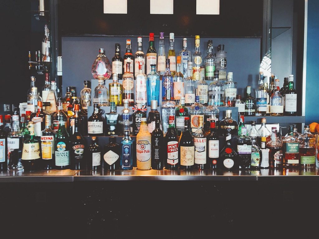 A wide selection of liquor bottles displayed on a bar shelf
