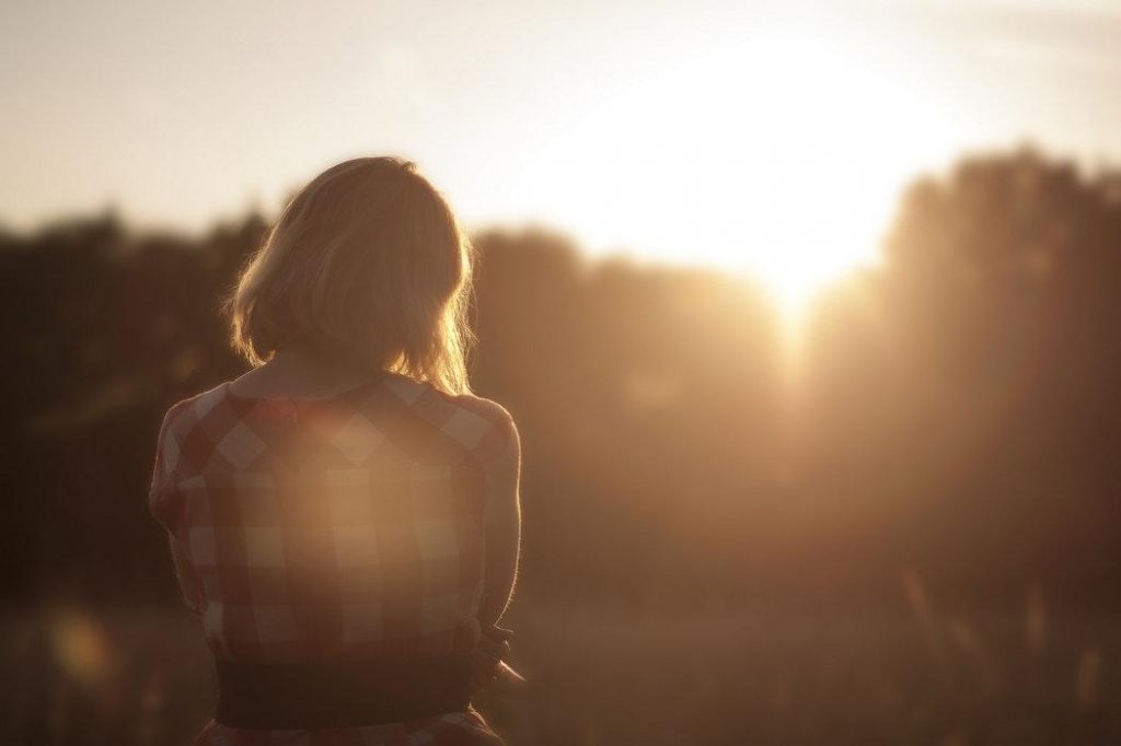 Woman sitting outdoors during sunset