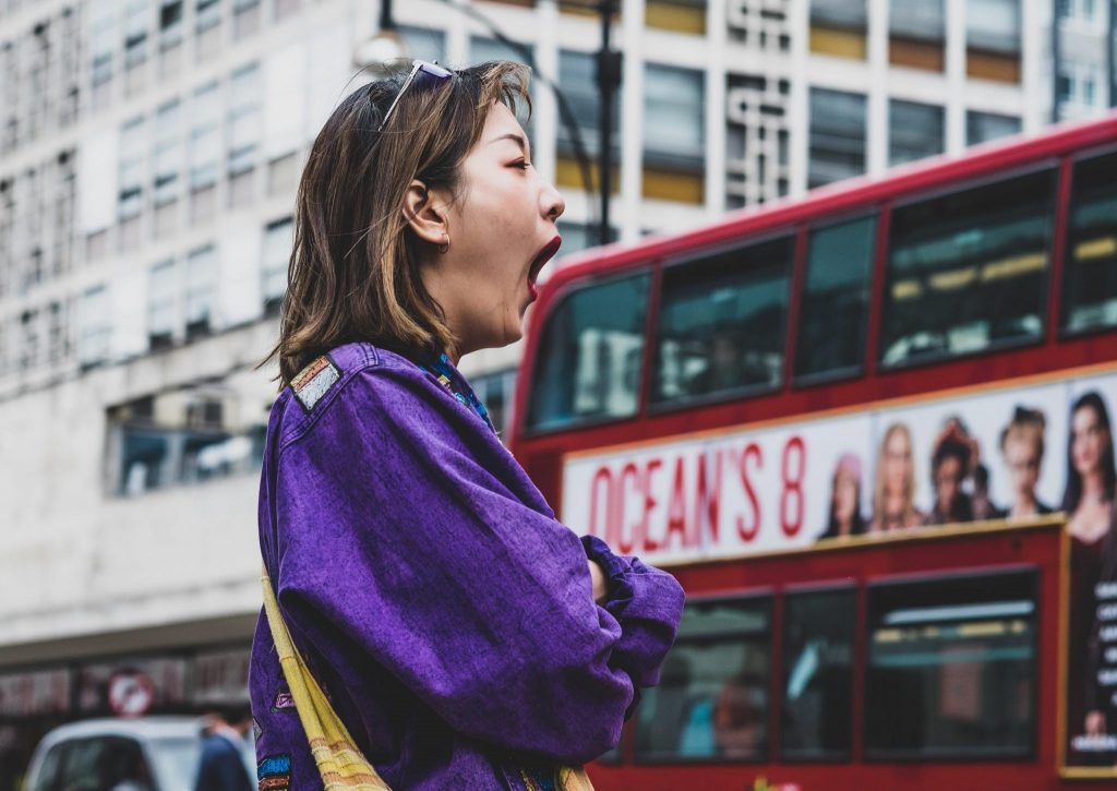 Girl feeling sleepy while walking on road
