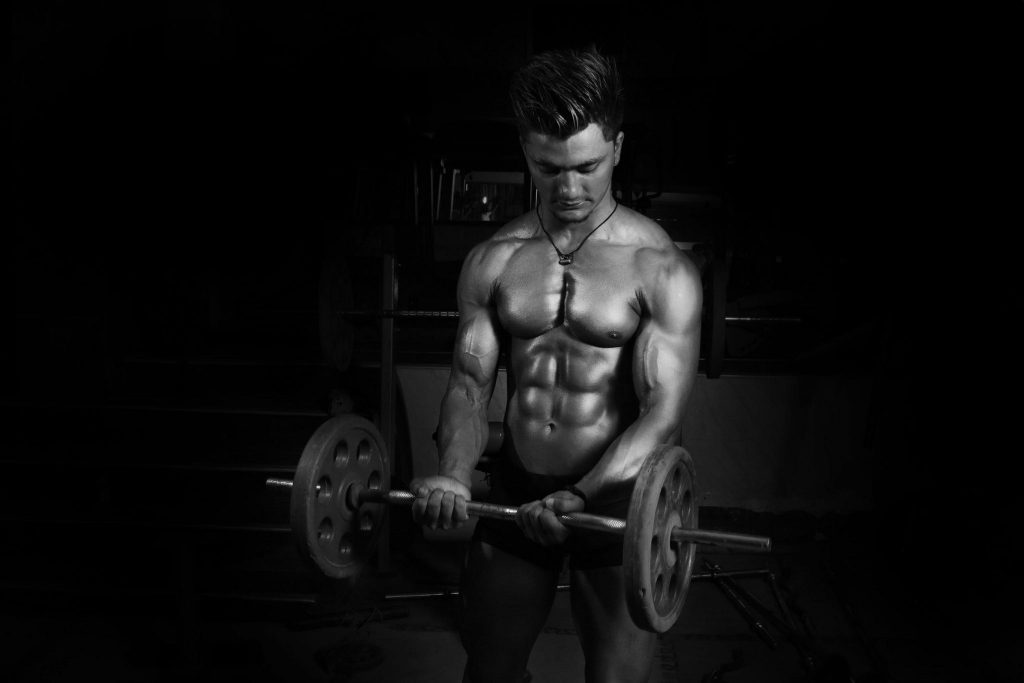 Muscular man lifting a barbell in a gym