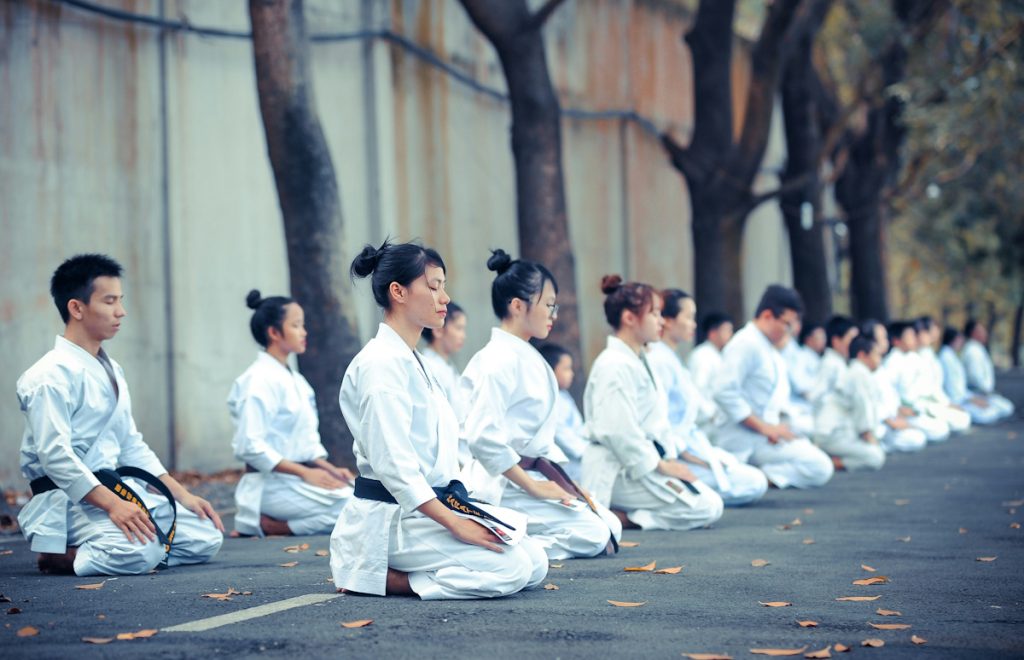 A group of person is doing meditation on the street roads